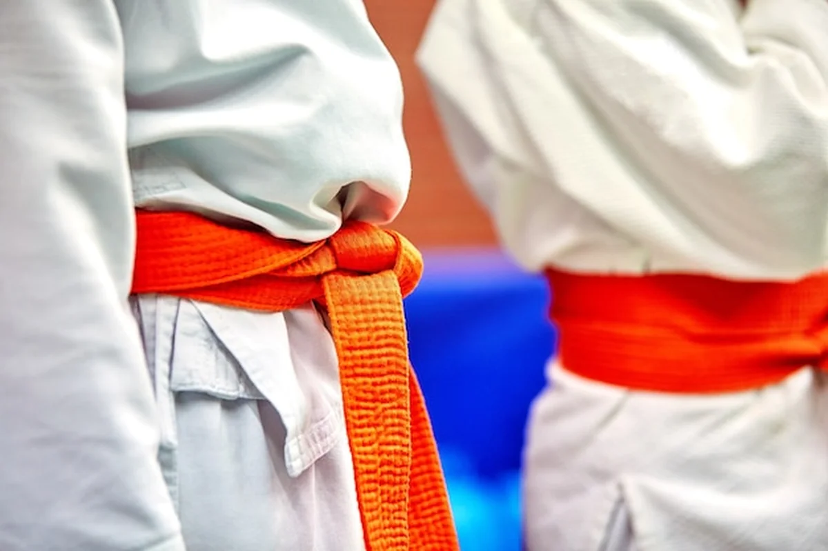 Sala karate przed treningiem - uczniowie w kimono i pasach