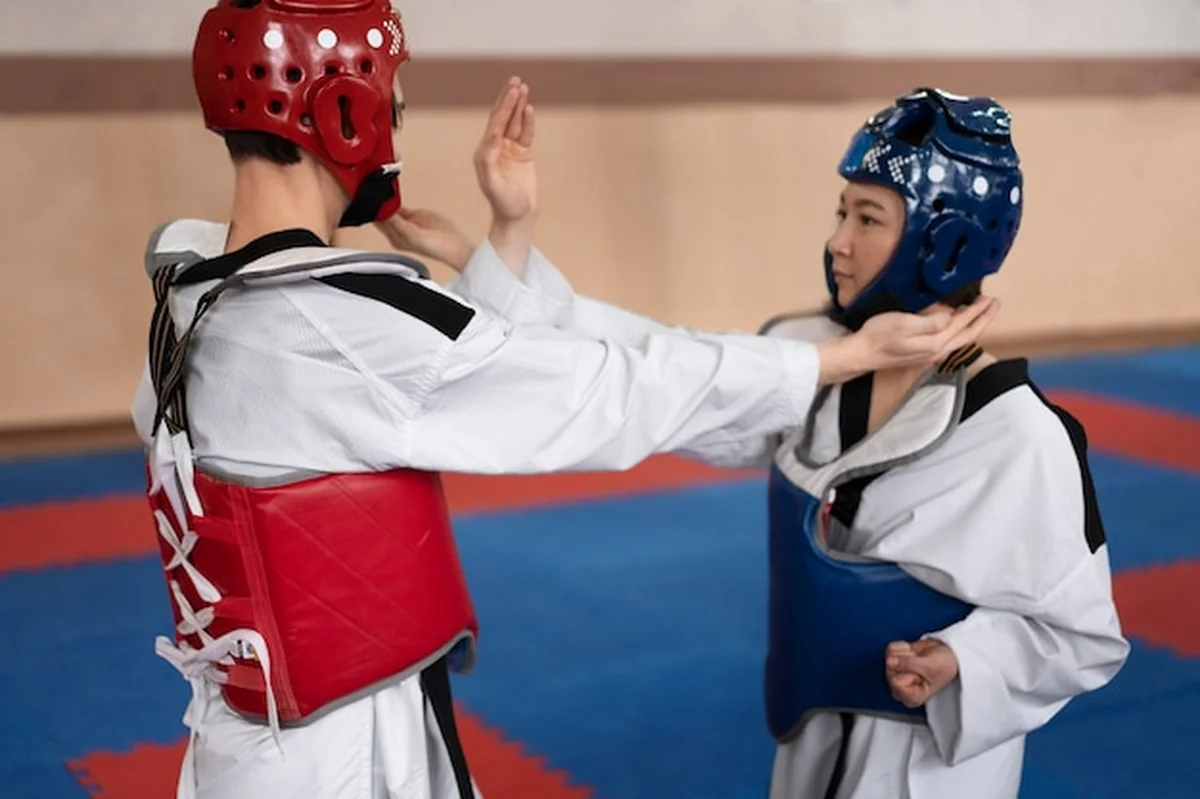 Ćwiczący taekwondo w sali gimnastycznej
